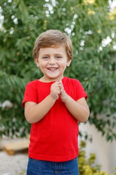 Happy child with red t-shirt playing in the garden