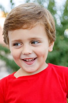 Happy child with red t-shirt playing in the garden
