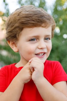 Happy child with red t-shirt playing in the garden