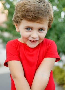Happy child with red t-shirt playing in the garden