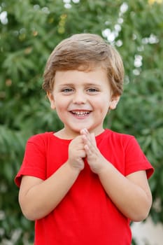 Happy child with red t-shirt playing in the garden