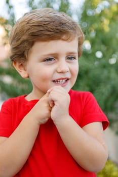 Happy child with red t-shirt playing in the garden