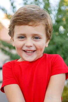 Happy child with red t-shirt playing in the garden