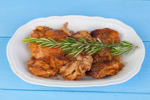 Source of chicken in sauce with a sprig of rosemary on top