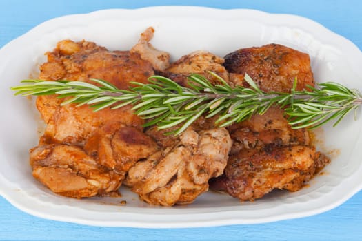 Source of chicken in sauce with a sprig of rosemary on top