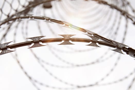 Fence with a barbed wire under a blue sky