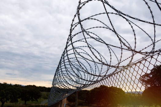 Fence with a barbed wire under a blue sky