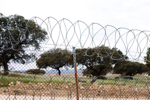 Fence with a barbed wire under a blue sky