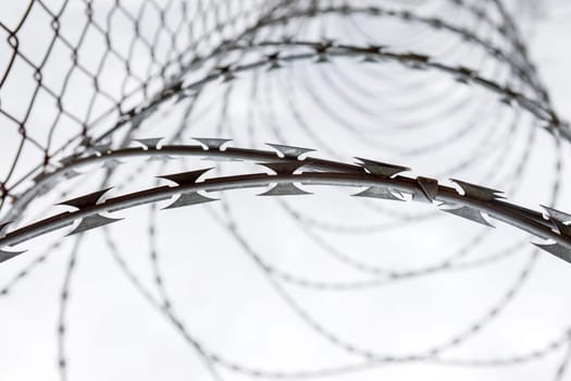 Fence with a barbed wire under a blue sky