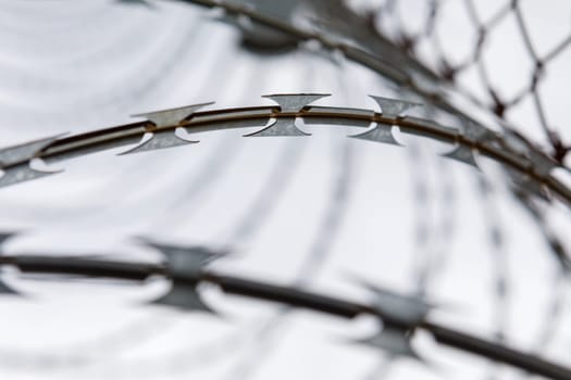 Fence with a barbed wire under a blue sky