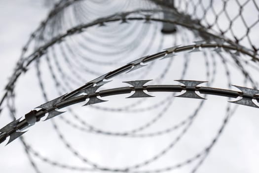 Fence with a barbed wire under a blue sky