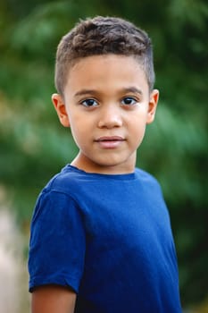 Beautiful latin child with a green natural background