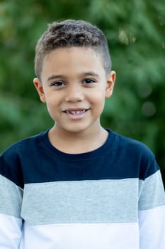 Adorable latin child in the garden with a beautiful green of background
