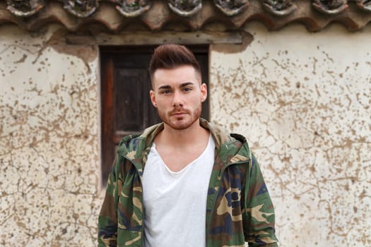 Atractive guy with jacket with military stylish in a vintage house