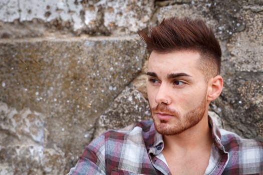 Attractive guy with beard and a old wall of background