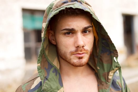 Fashion guy with green jacket looking at camera