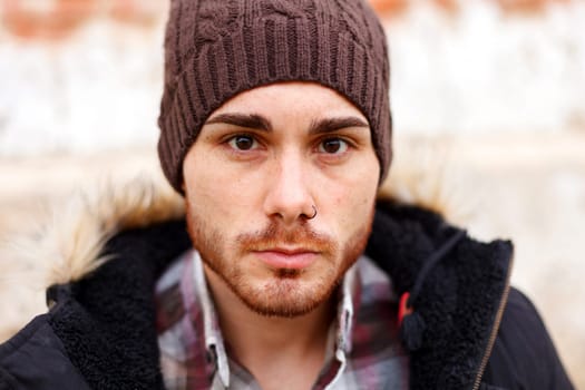 Sad guy with wool hat wearing a dark coat