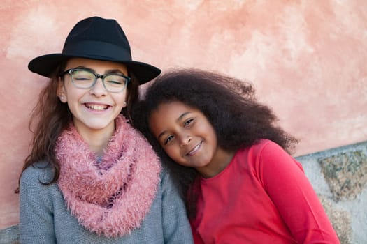 Two happy girls friends with stylish hats lauging