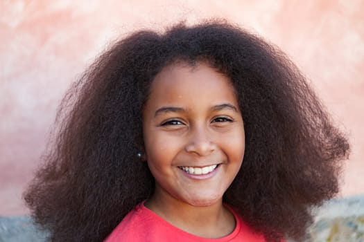 Pretty girl with long afro hair in the garden laughing