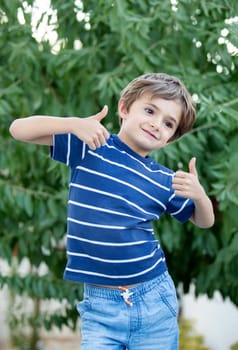 Happy child with long blond hair enjoying the nature and saying OK