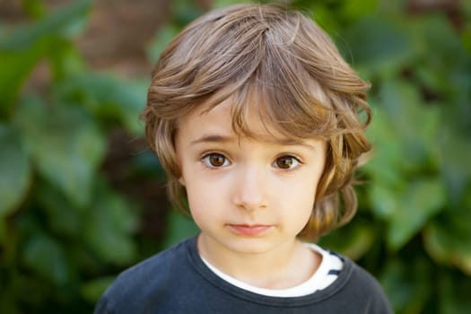 Adorable small child in the field looking at camera