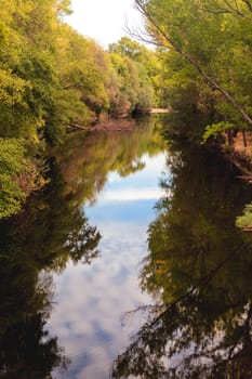 The river with a quiet current and trees reflected in it