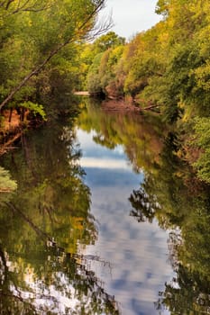 The river with a quiet current and trees reflected in it
