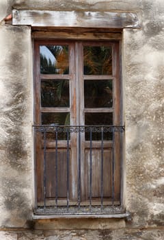 Old brown door of a balcony with iron railing