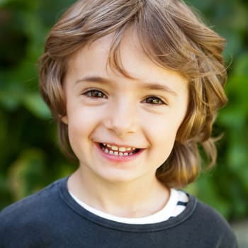 Adorable small child in the field looking at camera