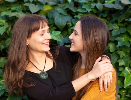 Outdoor portrait of two happy sisters relaxed in a park