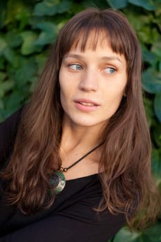 Beautiful woman with blue eyes and brown hair in the park