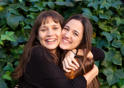 Outdoor portrait of two happy sisters relaxed in a park