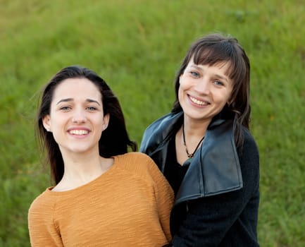 Outdoor portrait of two happy sisters relaxed in a park