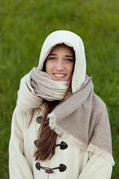 Sheltered girl with hood and scarf in the park