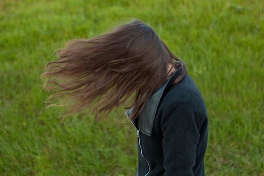 Outdoor portrait of beautiful happy girl laughing while the wind moves her hair