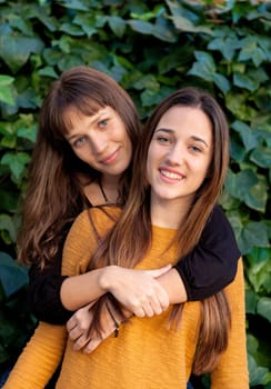 Outdoor portrait of two happy sisters relaxed in a park