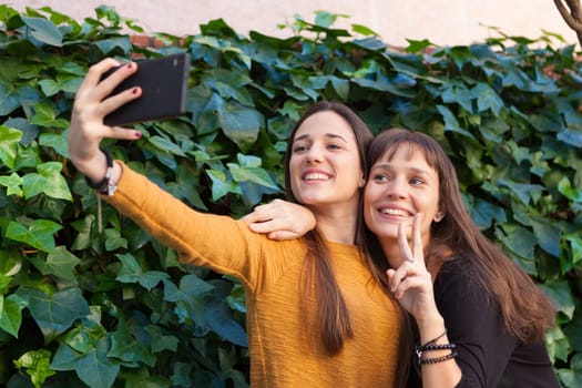 Two sisters enjoying of a day in the park with a mobile