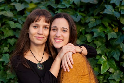 Outdoor portrait of two happy sisters relaxed in a park