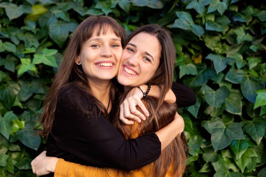 Outdoor portrait of two happy sisters relaxed in a park