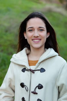 Smiling teen girl outside with a natural green of background