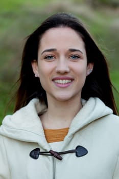 Smiling teen girl outside with a natural green of background