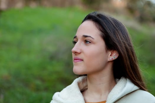 Smiling teen girl outside with a natural green of background