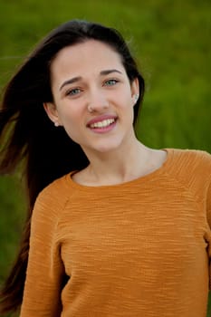 Outdoor portrait of beautiful happy teenager girl laughing with perfect teeth in field