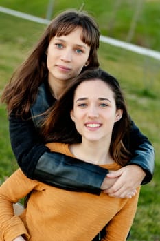 Outdoor portrait of two happy sisters relaxed in a park