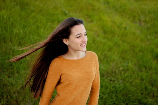 Outdoor portrait of beautiful happy teenager girl laughing with perfect teeth in field