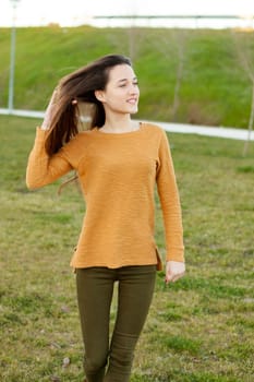 Outdoor portrait of beautiful happy teenager girl laughing while the wind moves her hair
