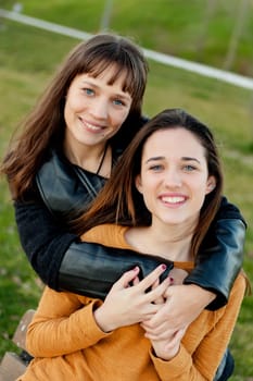 Outdoor portrait of two happy sisters relaxed in a park