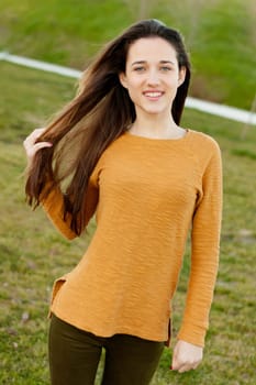 Outdoor portrait of beautiful happy teenager girl laughing while the wind moves her hair