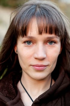 Beautiful brunette woman with blue eyes in the park
