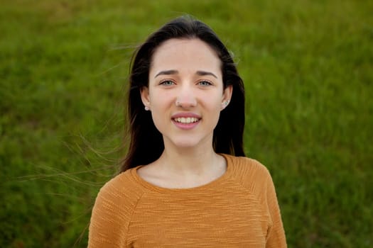 Outdoor portrait of beautiful happy teenager girl laughing with perfect teeth in field